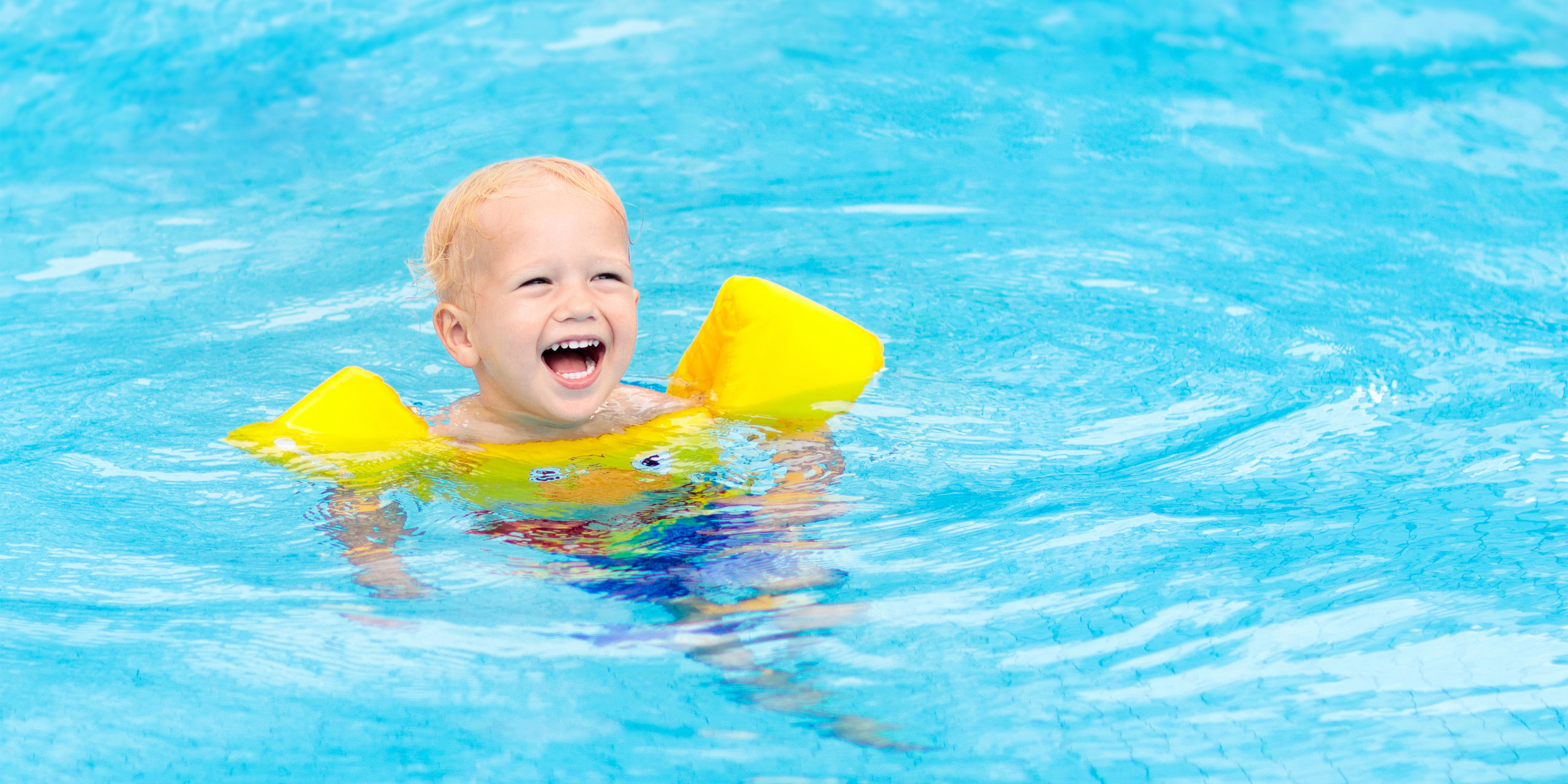 Toddler in Swimming Pool With Yellow Life Jacket