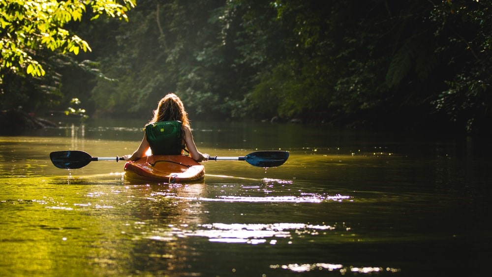 girl kayaking in lake