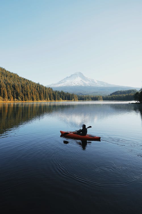 man kayaking in lake